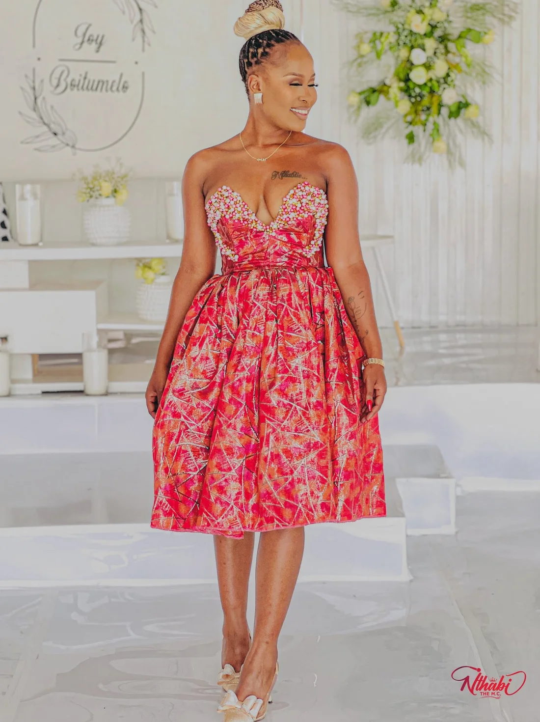 Nthabi walking in her crimson beaded dress